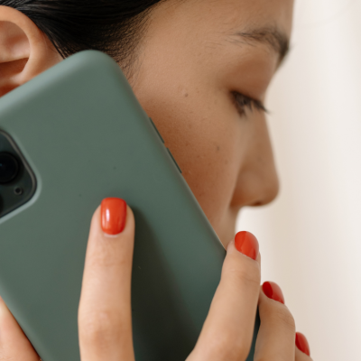 Close up of woman holding mobile phone close to ear, describing Life Charity's National Helpline to listen to people facing pregnancy issues
