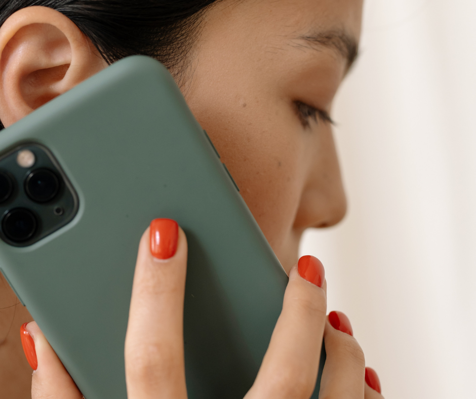 Close up of woman holding mobile phone close to ear, describing Life Charity's National Helpline to listen to people facing pregnancy issues