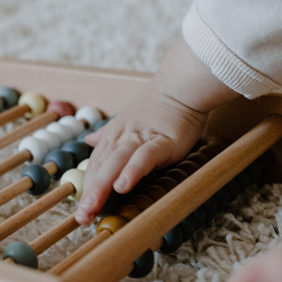 Baby with abacus. Life Charity asks - Free childcare, but ta what cost?