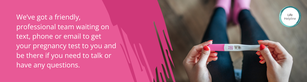 woman holding pregnancy test with pink socks life charity free pregnancy test offer online UK