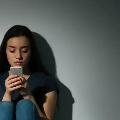 Young woman sitting on the floor while texting