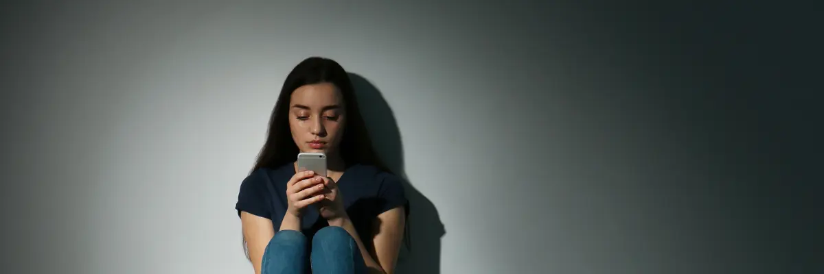 Young woman sitting on the floor while texting